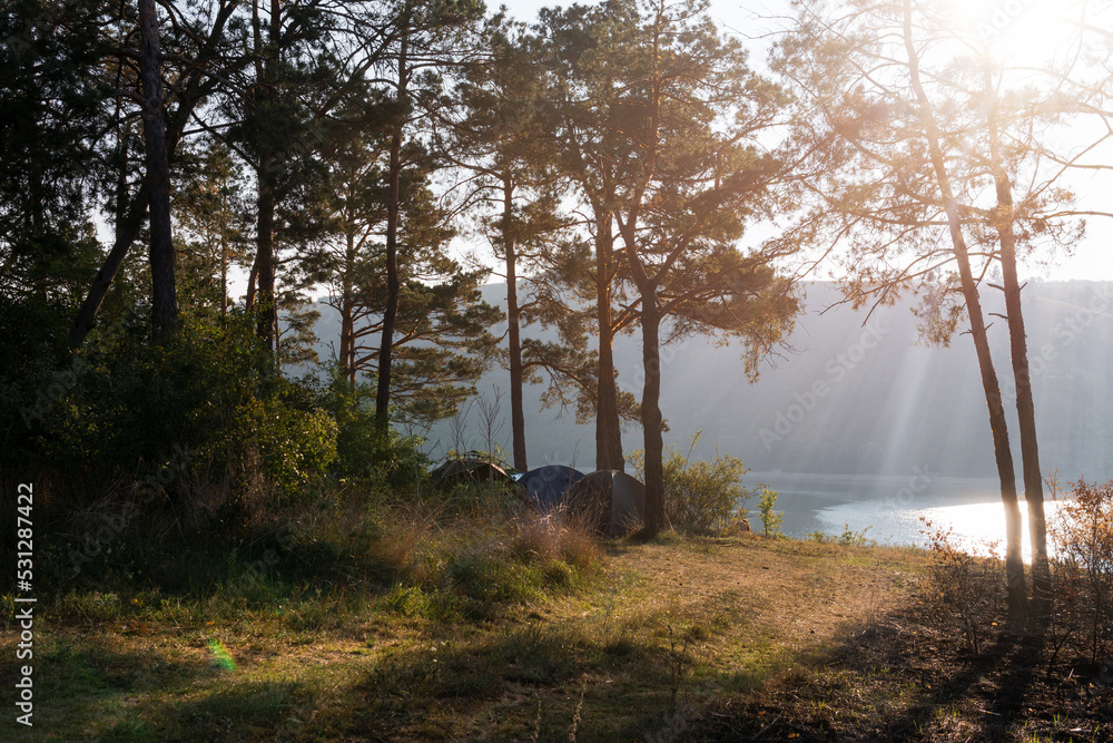 Distance view. Morning landscape. Pine forest, sun rays, glow, river lake, mountains. Summer camping warm colors. Tourism and vacation. Distance view. Morning landscape. Pine forest, sun rays, glow, river lake, mountains. Summer camping warm colors. Tourism and vacation.