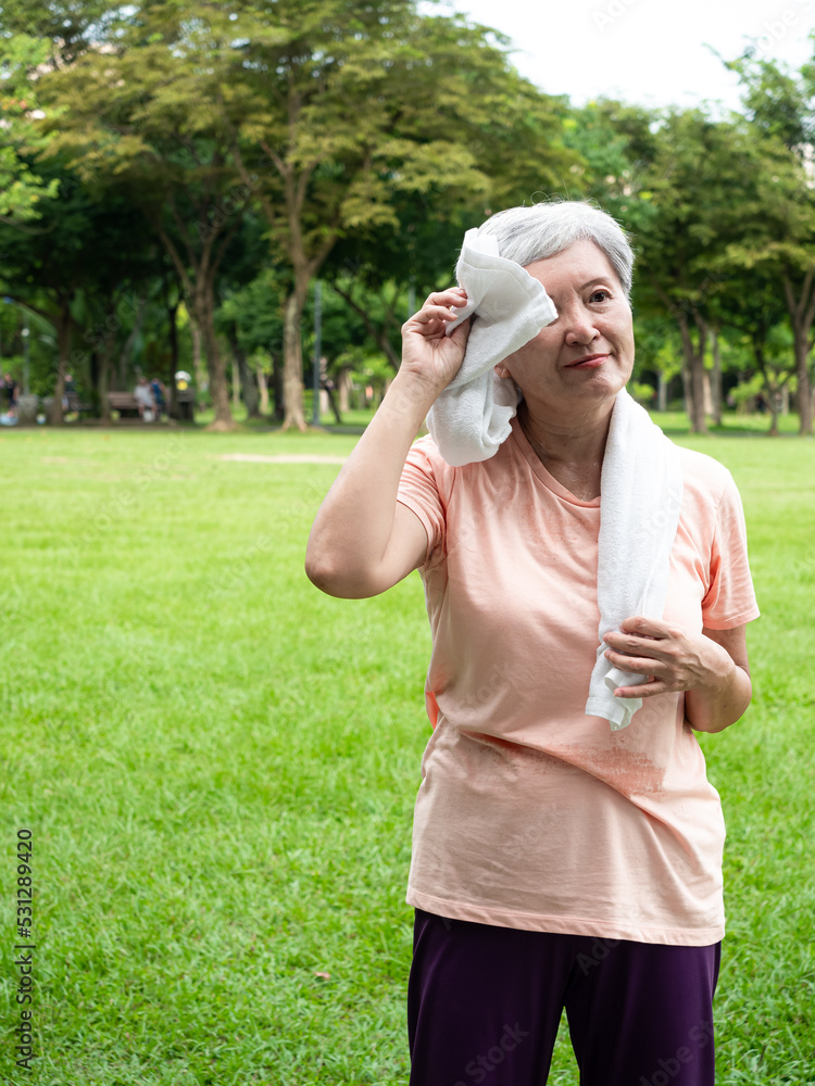 Portrait of 60s senior adult elderly asia woman smiling standing with towel after sport and enjoy with nature fresh air in the park. Portrait of 60s senior adult elderly asia woman smiling standing with towel after sport and enjoy with nature fresh air in the park.