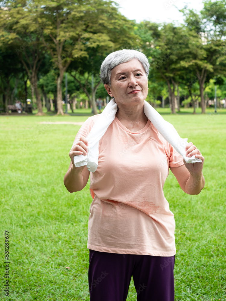 Portrait of 60s senior adult elderly asia woman smiling standing with towel after sport and enjoy with nature fresh air in the park. Portrait of 60s senior adult elderly asia woman smiling standing with towel after sport and enjoy with nature fresh air in the park.