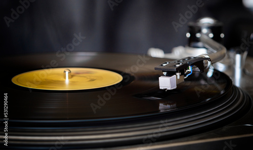 Record turntable spinning with an album and stylus on a black background
