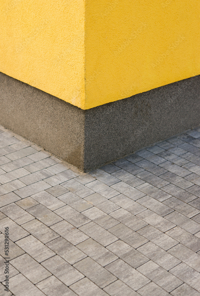 house corner, yellow cement wall and paving slabs house corner, yellow cement wall and paving slabs