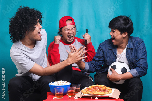 Fotografía Happy friends or football fans watching soccer on tv and celebrating victory
