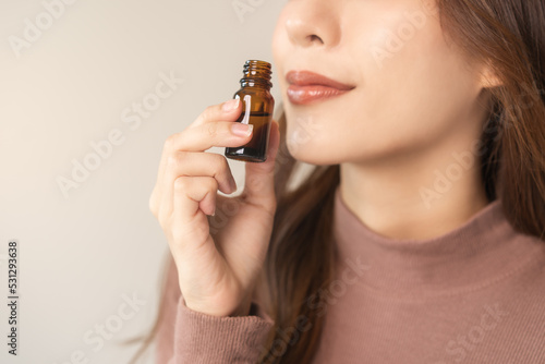 Aromatherapy, attractive asian young woman hand holding bottle of essential perfume oil, enjoying smell fragrance of herbal from medicine natural organic at home. Therapy treatment, beauty skin care.