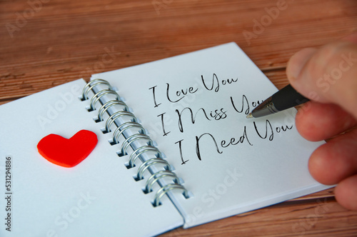 I love you text on notepad with wooden cover and pen background. Romance and relationship concept