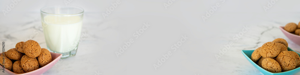 Amaretti cookies and glass of milk drink banner. Small soft Italian traditional sweet-bitter pastry dessert. Amaretti cookies and glass of milk drink banner. Small soft Italian traditional sweet-bitter pastry dessert.