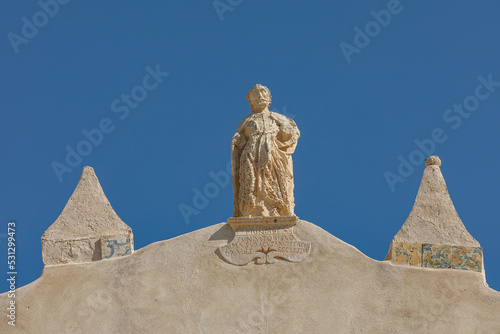 Sattue on the facade of the Basilica named to San Giovanni Evangelisata, Syracuse, Sicily, Italy photo