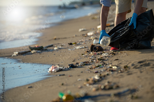 Volunteer garbage collector on Pattaya beach, Thailand in monsoon season, ecology concept