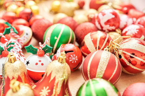 Box of mixed Christmas tree ornaments, balls and bells in the classic traditional colors of red, green, white and gold.