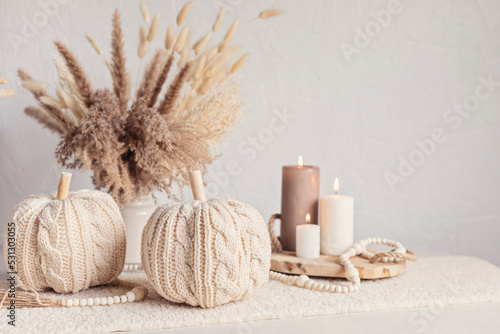 Autumn table decoration. Interior decor for fall holidays with handmade pumpkins and candles. Holiday greeting card