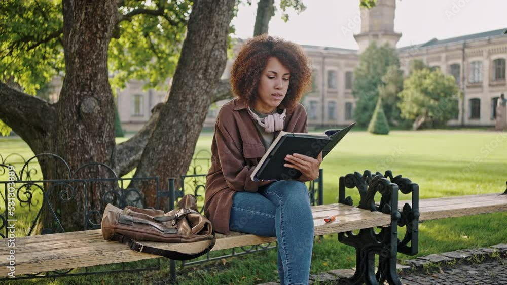 African American woman reads report in exercise book
