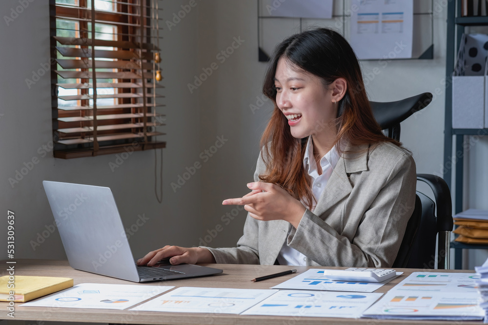Businesswoman presenting profit data with graphs to her supervisor via laptop computer. Businesswoman presenting profit data with graphs to her supervisor via laptop computer.