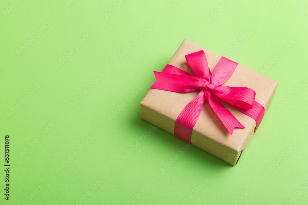 Wrapped christmas or other holiday handmade present in craft paper with colored ribbon. Present box, decoration of gift on table, top view with copy space Wrapped christmas or other holiday handmade present in craft paper with colored ribbon. Present box, decoration of gift on table, top view with copy space