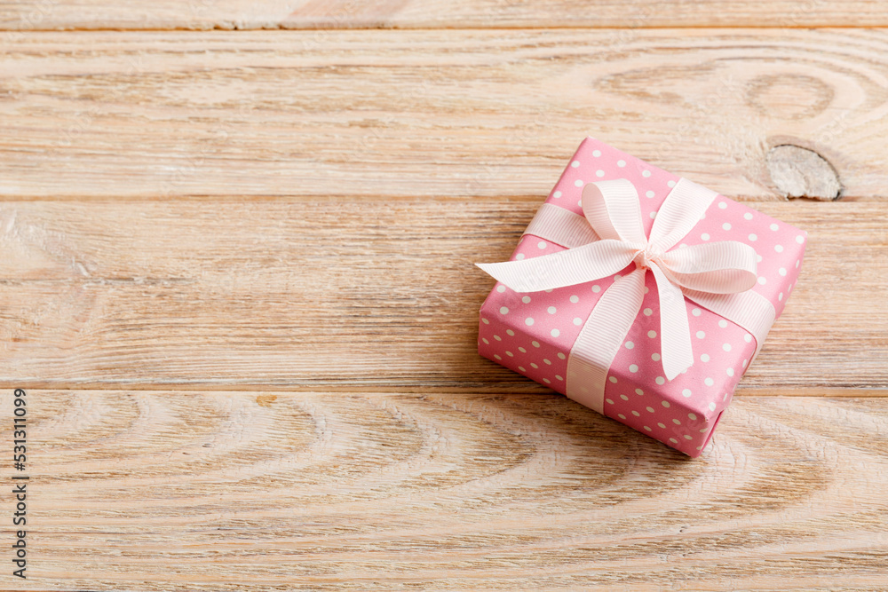wrapped Christmas or other holiday handmade gift box in color paper with ribbon on colored background. Present box, decoration of gift on colored table, top view with copy space wrapped Christmas or other holiday handmade gift box in color paper with ribbon on colored background. Present box, decoration of gift on colored table, top view with copy space