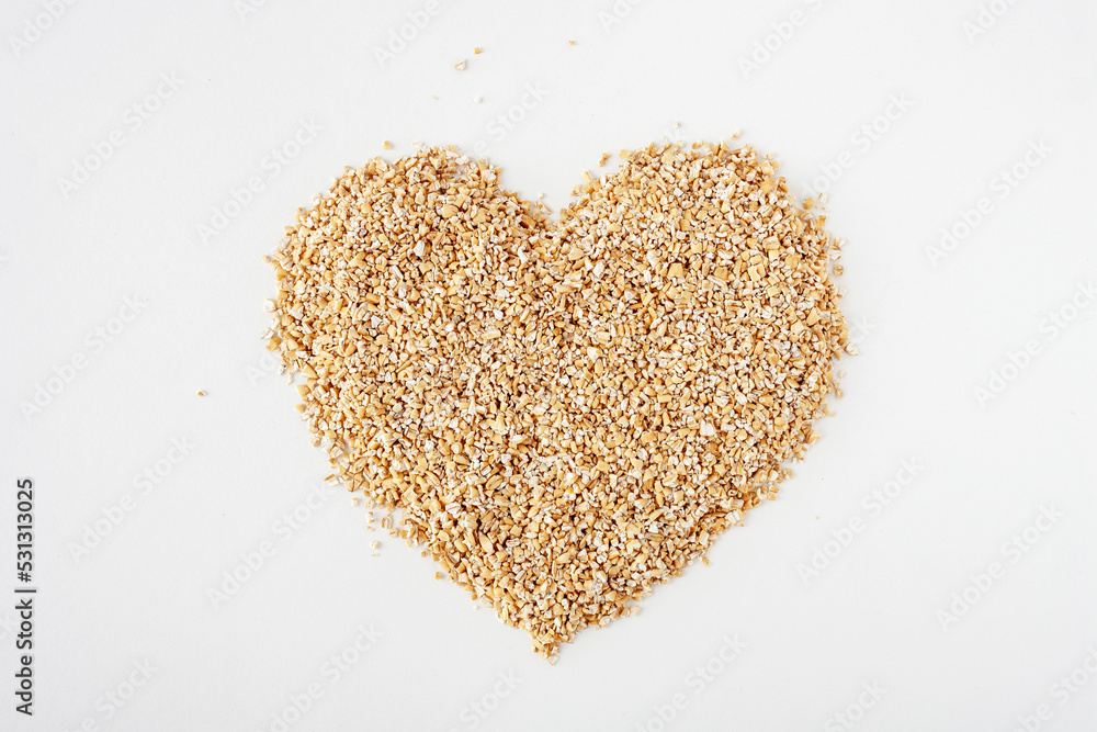 crushed oats are scattered on a white background in the shape of a heart, copy space crushed oats are scattered on a white background in the shape of a heart, copy space