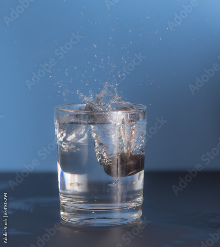 Healthy water splashing freshness with berry dropping - blue background