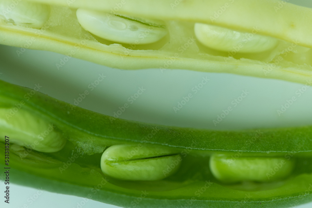 Green and yellow beans against white background, natural shadow under it. Macro shot. Green and yellow beans against white background, natural shadow under it. Macro shot.