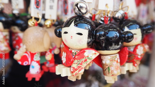 Tokyo Japan : closeup and blur background of Japanese small eyes, smile white happy face and black hair in red Kimono Doll Ring Souvenirs in store at Asakusa street, Sensoji temple