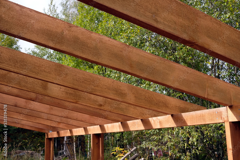 Obraz na plátně The process of building a wooden canopy from brown boards in the rural place in