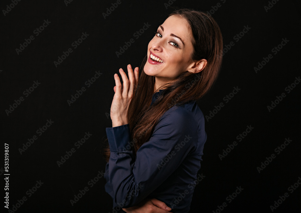 Beautiful thinking toothy laughing business woman with hand near the face in blue shirt on black background with empty copy space for text. Closeup Beautiful thinking toothy laughing business woman with hand near the face in blue shirt on black background with empty copy space for text. Closeup
