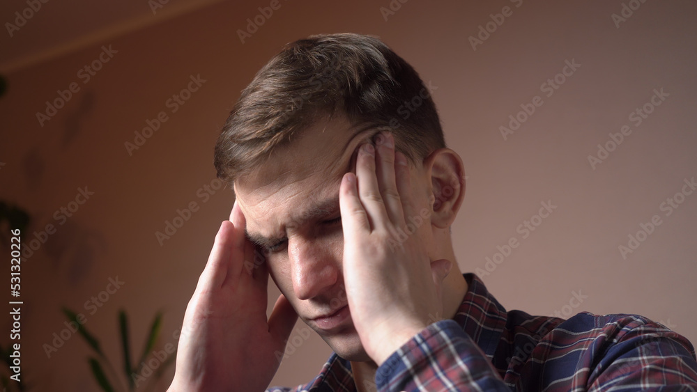 Tired young caucasian man massaging the temples of the head. migraine. Tired young caucasian man massaging the temples of the head. migraine.