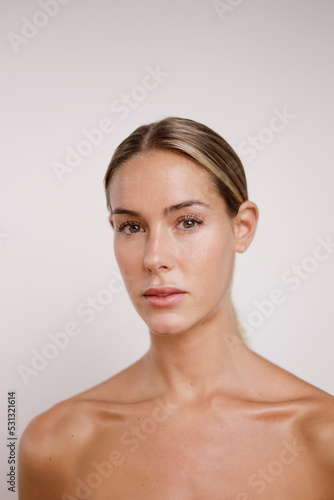 beauty portrait with bare shoulders of Caucasian woman looking at camera without makeup