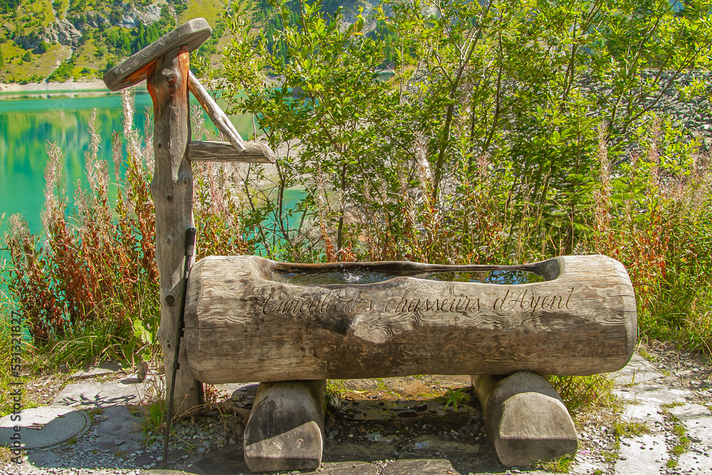Wooden water fountain in the mountains of the alpine valleys Wooden water fountain in the mountains of the alpine valleys