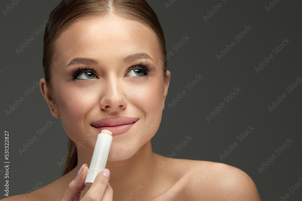 Lips Skin Care. Beautiful Woman Face With Lips Applying Hygienic Lip Balm, Lip Care Stick. Closeup Of Female Face With Soft Skin Putting Lip Protector Lipstick On. Beauty Cosmetics Concept. Lips Skin Care. Beautiful Woman Face With Lips Applying Hygienic Lip Balm, Lip Care Stick. Closeup Of Female Face With Soft Skin Putting Lip Protector Lipstick On. Beauty Cosmetics Concept.
