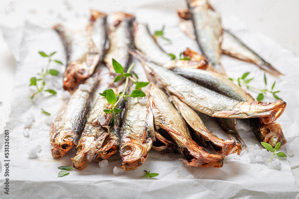 Healthy smoked sprats with herbs and salt.
