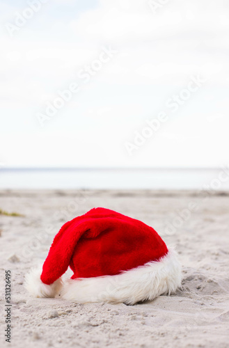 Christmas background Santa Claus hat on the beach 