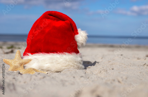 Christmas background Santa Claus hat on the beach with starfish