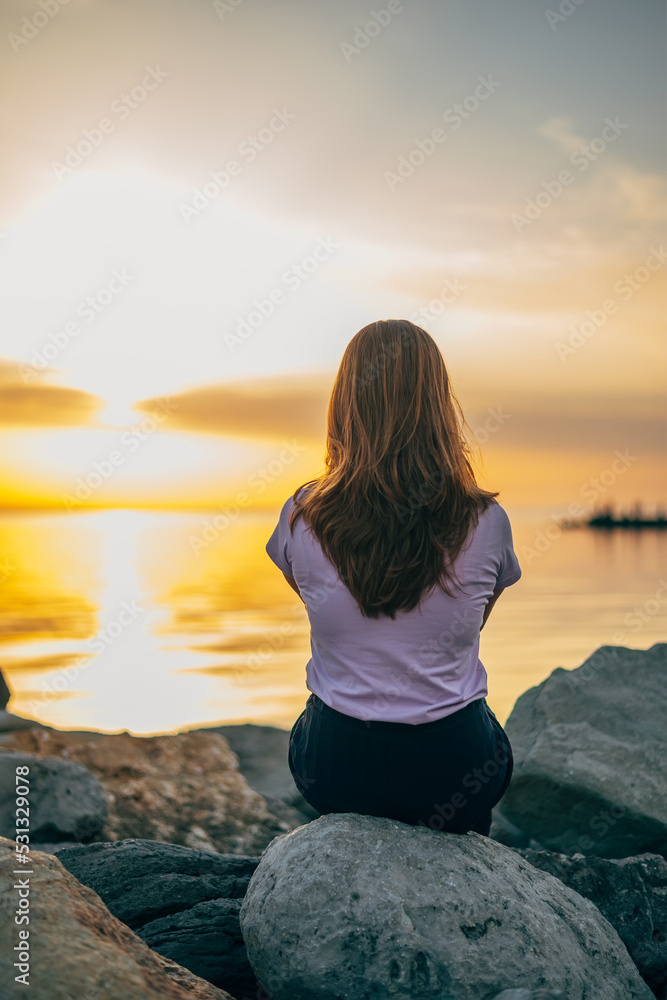close-up portrait of a woman from the back at sunset on the sea, ocean on a trip close-up portrait of a woman from the back at sunset on the sea, ocean on a trip