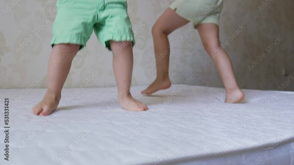Close up of two little children, brother and sister, jumping on mattress. Cheerful active kids having fun playing during the repair.Leisure activity, lot of energy, hyperactive kid concept.Childhood. Close up of two little children, brother and sister, jumping on mattress. Cheerful active kids having fun playing during the repair.Leisure activity, lot of energy, hyperactive kid concept.Childhood.