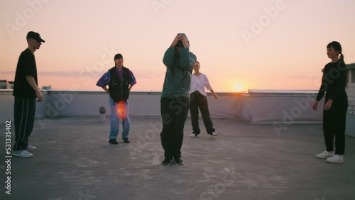 cool boy is dancing breakdance in street dance battle on roof, youth hang out together and have fun