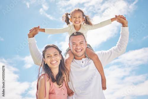 Happy family portrait and smile together in summer with a blue sky background. Energetic dad and mother play and having fun with their child. Cheerful father carrying daughter on shoulders outdoor