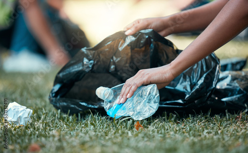 Hands, plastic bottle and recycling volunteer woman cleaning up garbage and environment trash park problem. Sustainability, eco friendly recycle and volunteering girl with sustainable black waste bag