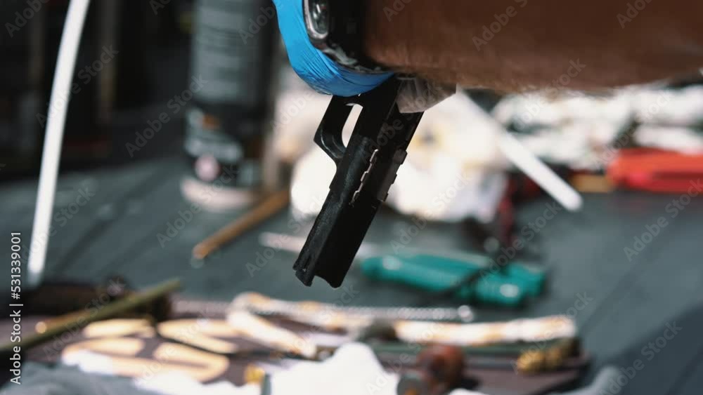 Renovating older gun. Black firearm being held and cleaned by unrecognizable caucasian person in protective blue gloves. Outdoor shot. High quality 4k footage Renovating older gun. Black firearm being held and cleaned by unrecognizable caucasian person in protective blue gloves. Outdoor shot. High quality 4k footage