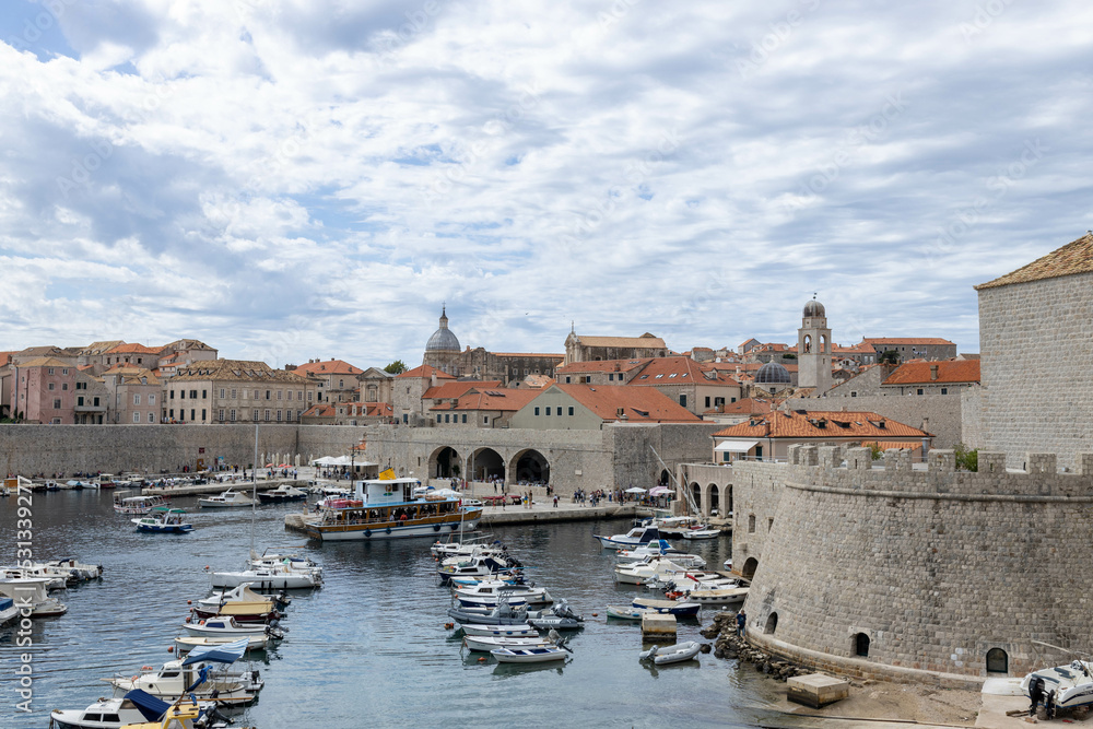 Dubrovnik, Croatia - September 21, 2021: Croatian city on the Adriatic Sea with fortress. Panorama view. Boats and ships in harbor in old town. Prominent travel destination. UNESCO World Heritage Site