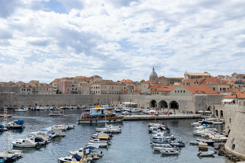 Dubrovnik, Croatia - September 21, 2021: Croatian city on the Adriatic Sea with fortress. Panorama view. Boats and ships in harbor in old town. Prominent travel destination. UNESCO World Heritage Site