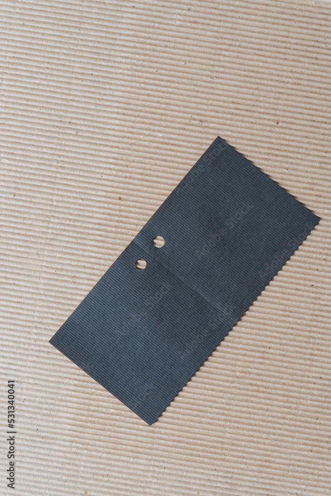 plain brown corrugated paper and unfolded black paper gift tag