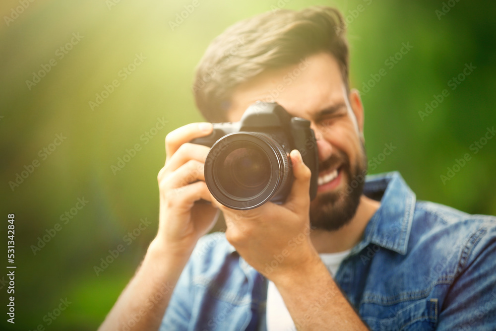 Photographer taking photo with professional camera in park