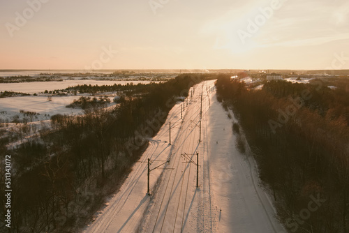 Aerial view of a railroad among pine forests at winter.