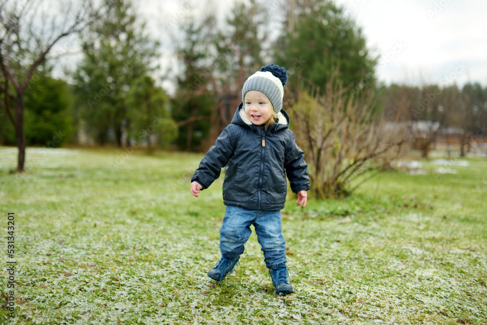 Funny toddler boy having fun outdoors on chilly winter day. Child exploring nature. Funny toddler boy having fun outdoors on chilly winter day. Child exploring nature.