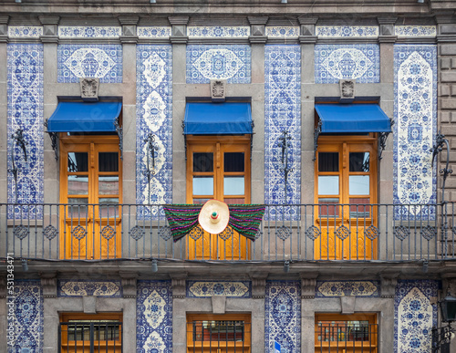 facade of colonial mexican house covered in blue talavera tiles, and a balcony with three doors, puebla city Mexico photo