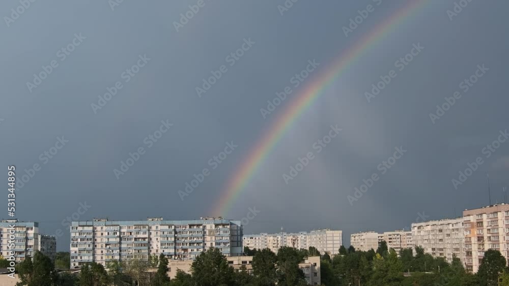Bright rainbow in the sky over the city. Big colorful rainbow over ...