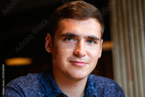 Defocus portrait young man on vintage background. Smiling young man with blue eyes. 20s years. Handsome man outdoors portrait. Lifestyle. Student. Closeup. Out of focus photo