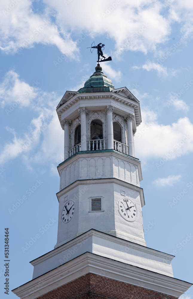 A historic clock tower in Camden, South Carolina, USA, against a blue sky.