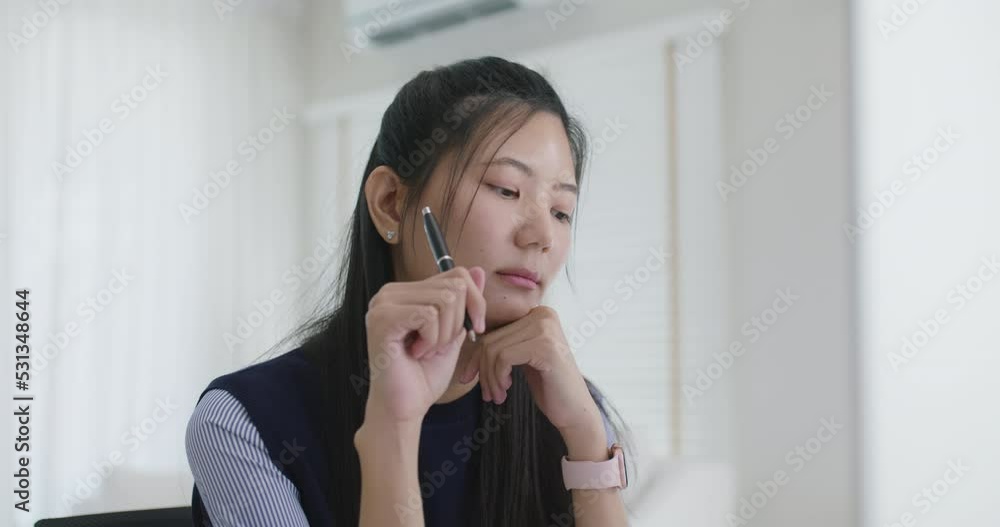Young asia people female workforce sit on desk table remote work at home office workspace look away concern of plan risk in analyst job career. Teen girl lady think hard doubt pensive in online class. Young asia people female workforce sit on desk table remote work at home office workspace look away concern of plan risk in analyst job career. Teen girl lady think hard doubt pensive in online class.