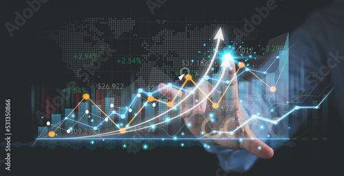 Man touching arrow on the virtual screen graphing corporate growth to the future with copy space analysis and plan investments for business profit goals. Business, Investment, and Finance concept.