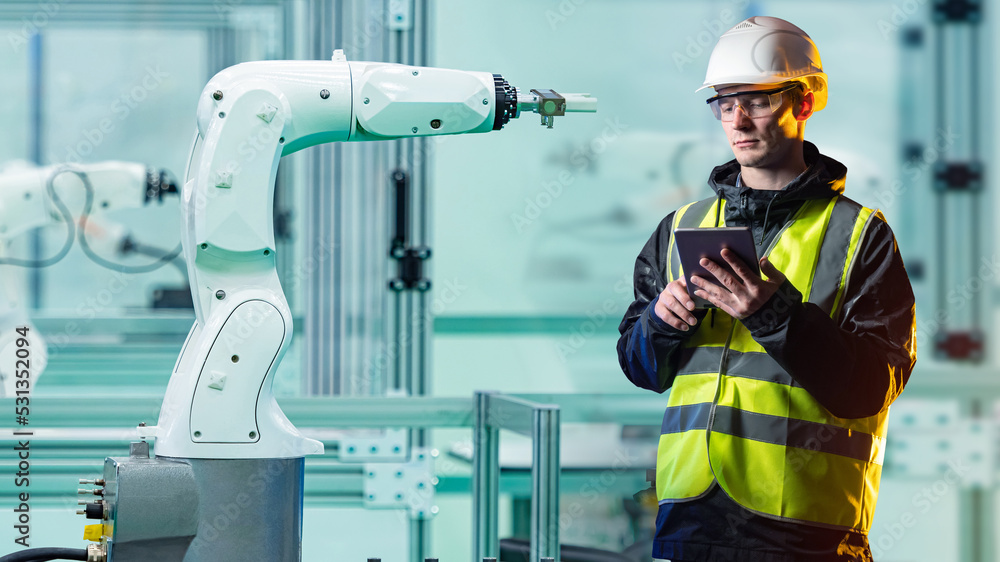Foto de Automation factory production. Man engineer and arm manipulator ...