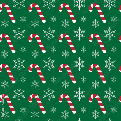 Christmas seamless pattern with candy canes and snowflakes on green background. For wrapping paper, fabric print, greeting cards design